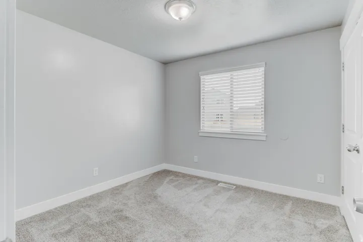 Room featuring light gray walls, white trim, and gray carpeting