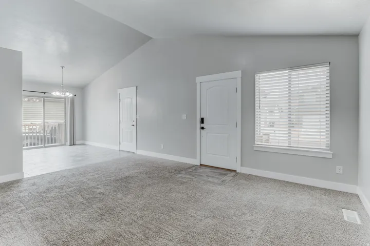 Vaulted ceilings complement the neutral-toned walls and plush carpet flooring