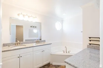 Bathroom featuring a dual vanity with granite countertops, undermount sinks, and brushed nickel fixtures