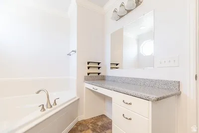 White built-in vanity with a speckled countertop, integrated mirror, and brushed nickel hardware