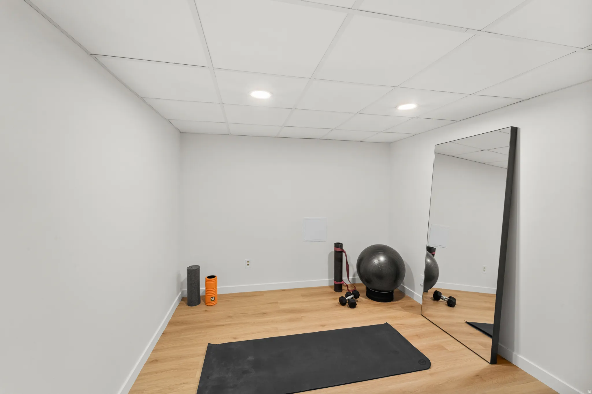 Versatile room featuring light wood-finish flooring, recessed lighting, and a neutral color palette