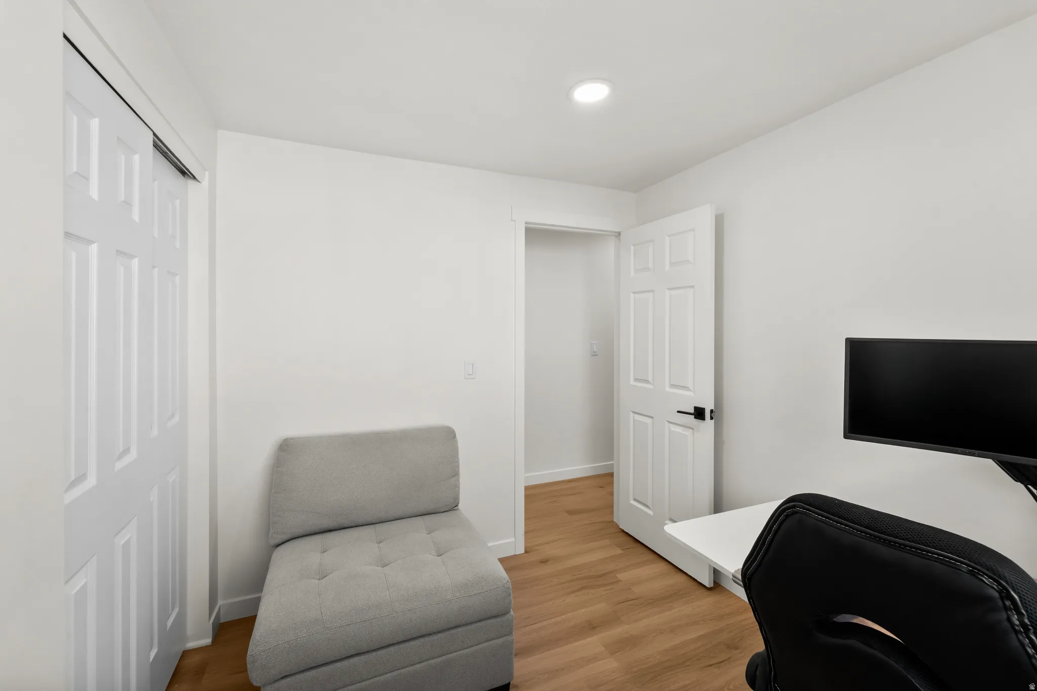 Room featuring wood-finish flooring and recessed ceiling lighting