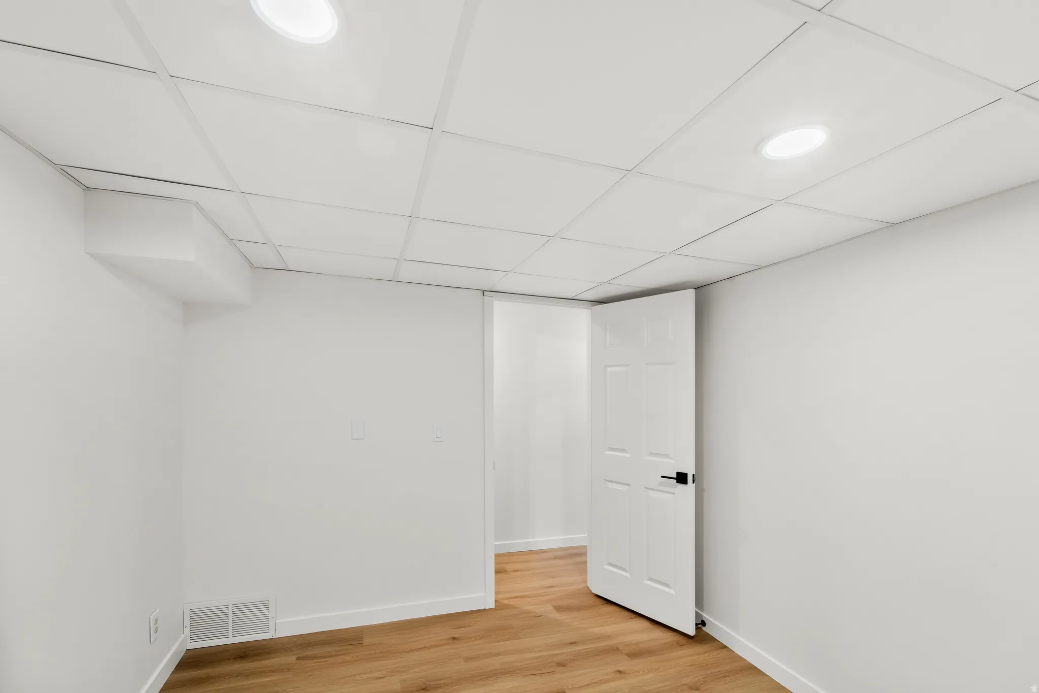 Room featuring wood-finish flooring, recessed lighting, and a drop ceiling