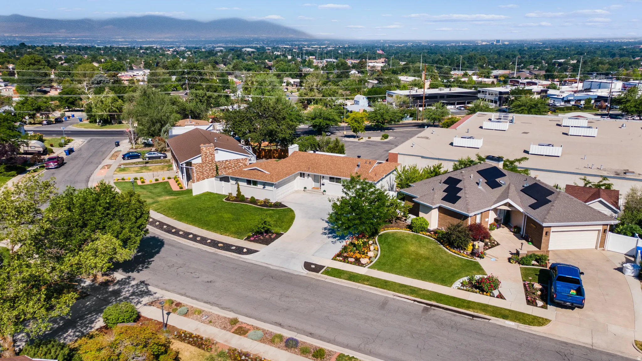Aerial perspective showcasing a residential property with a partial brick facade and an attached garage