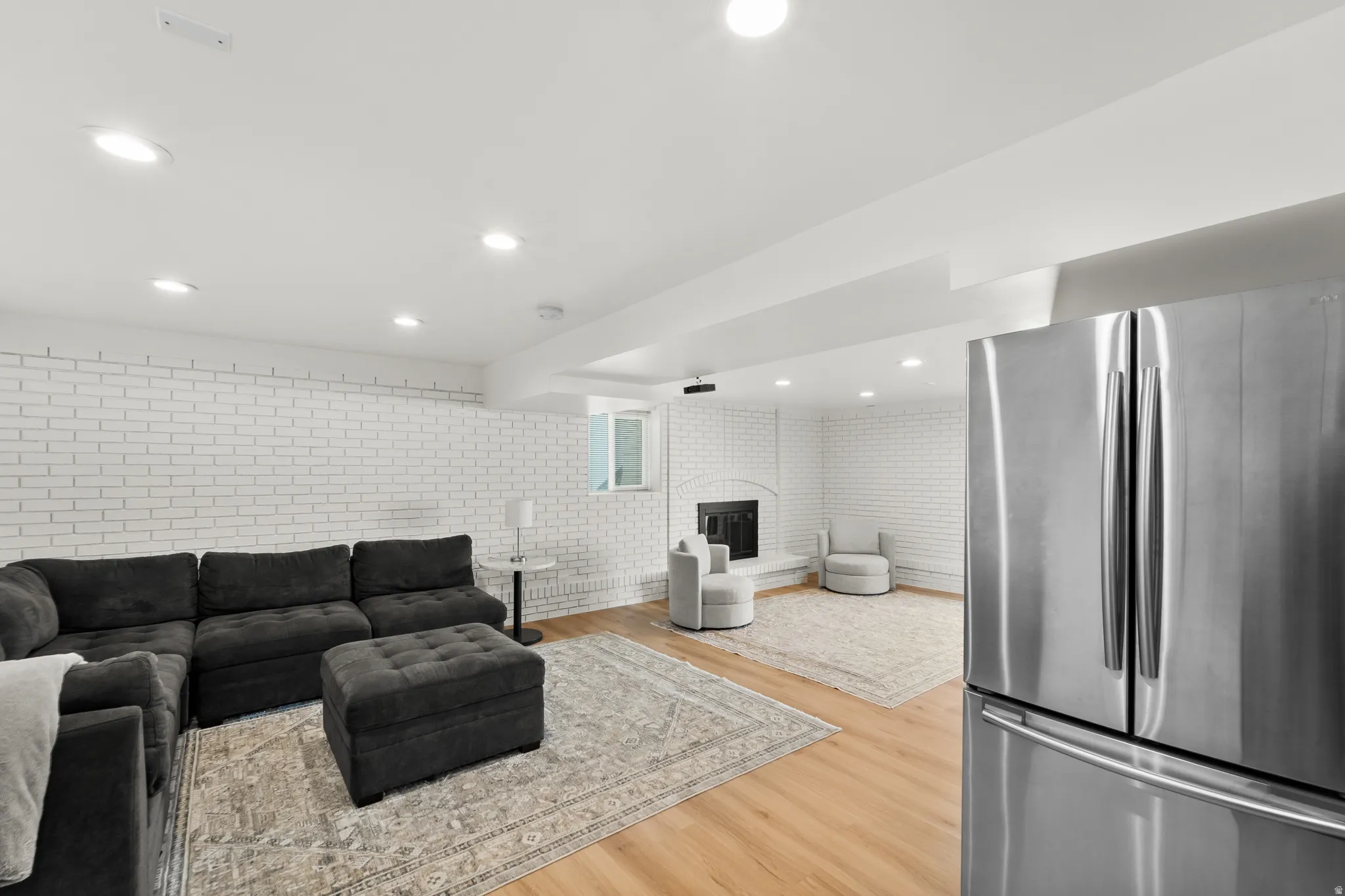 Spacious living area featuring light wood-finish flooring and recessed lighting