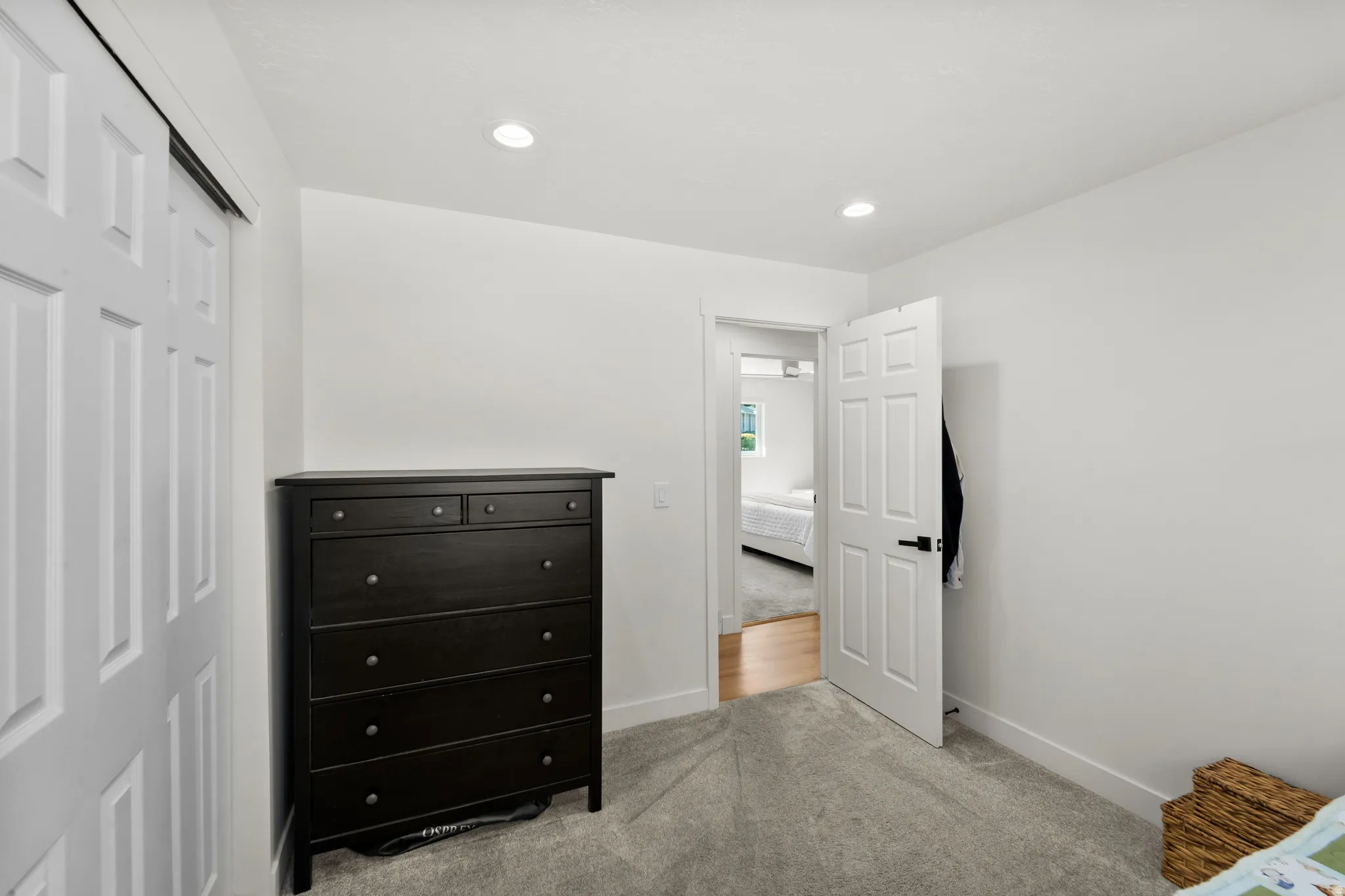 Light gray carpeted flooring paired with crisp white walls and recessed lighting
