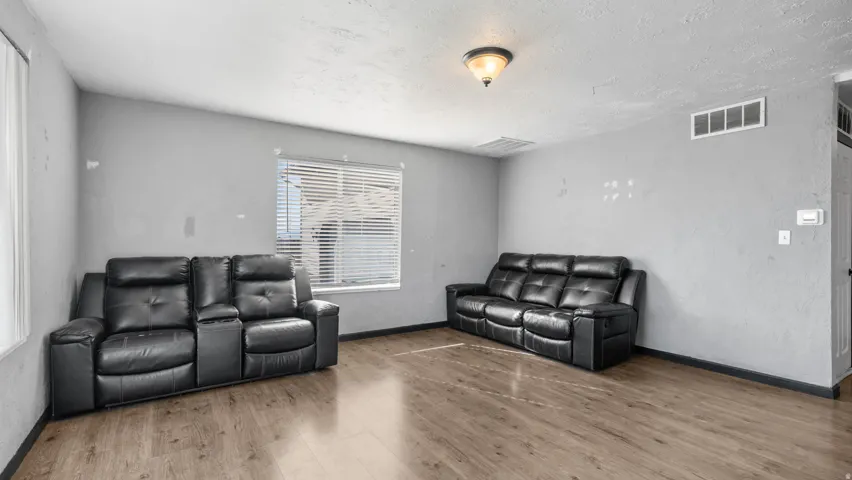 Wood-finish flooring, neutral wall tones, and a window with blinds