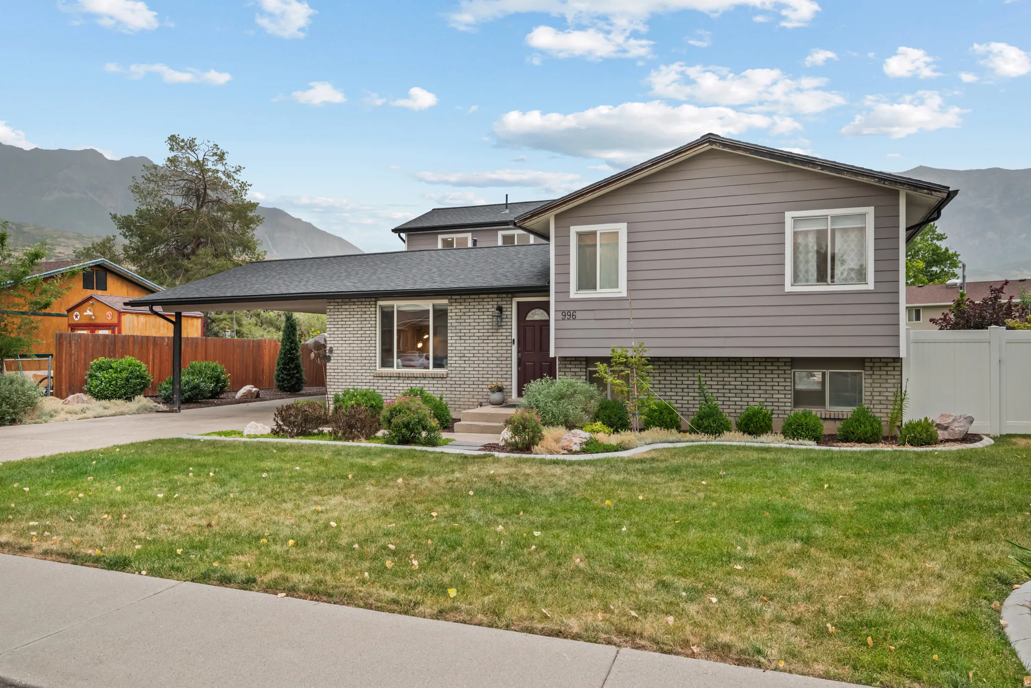 Split-level residence featuring a gray brick and siding exterior