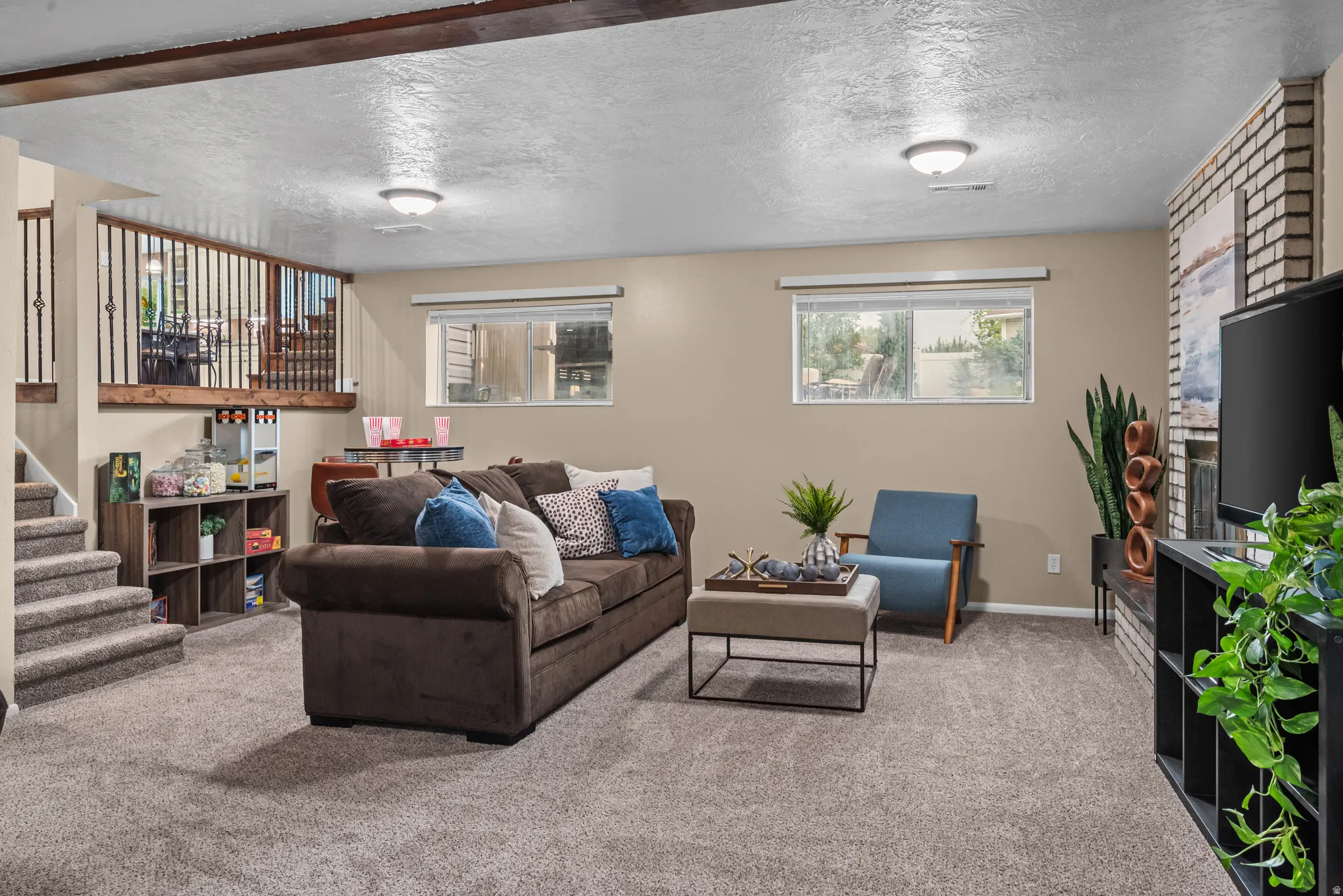 Lower level living area with neutral carpeting and paint