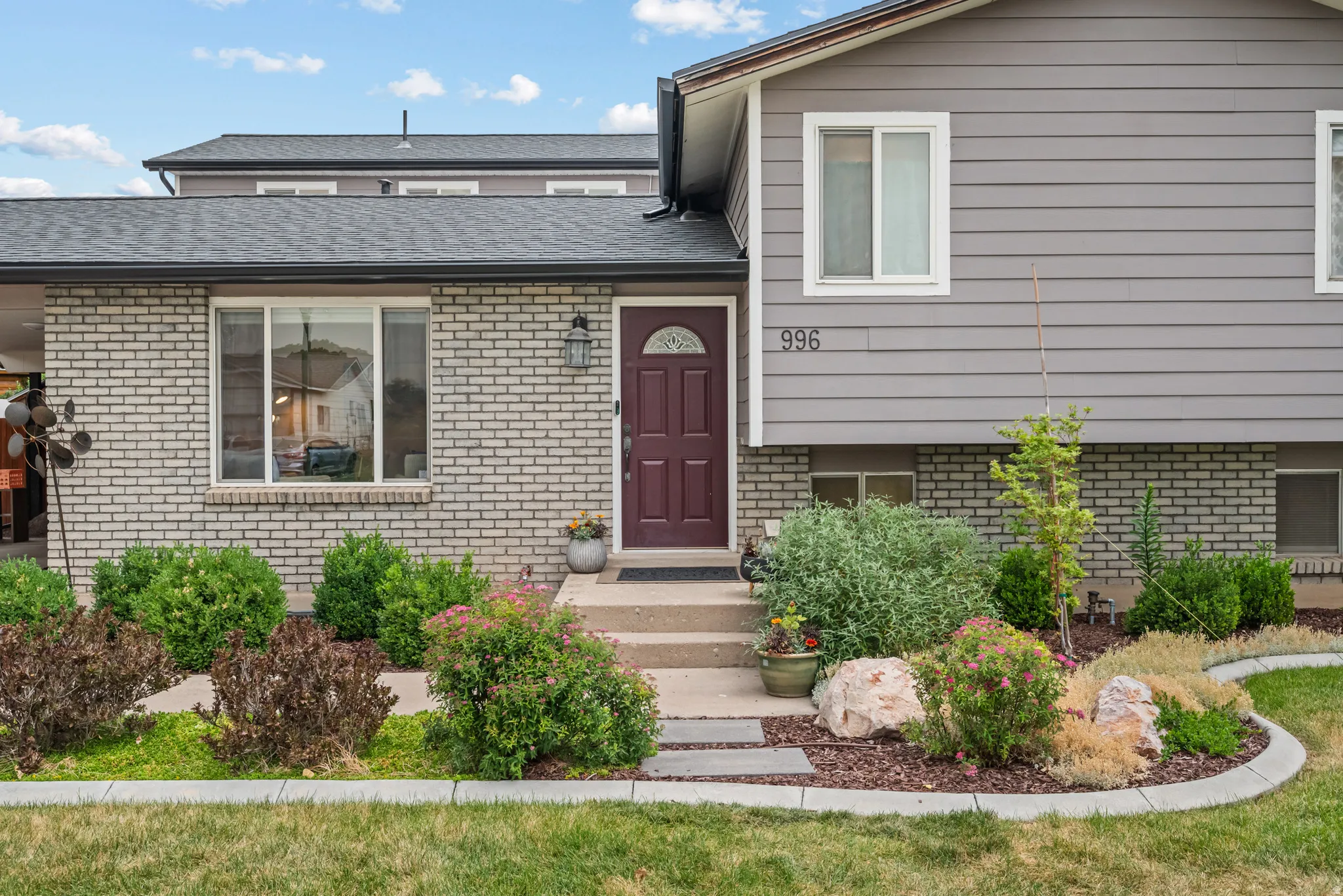 Contemporary exterior featuring gray siding and light brick accents