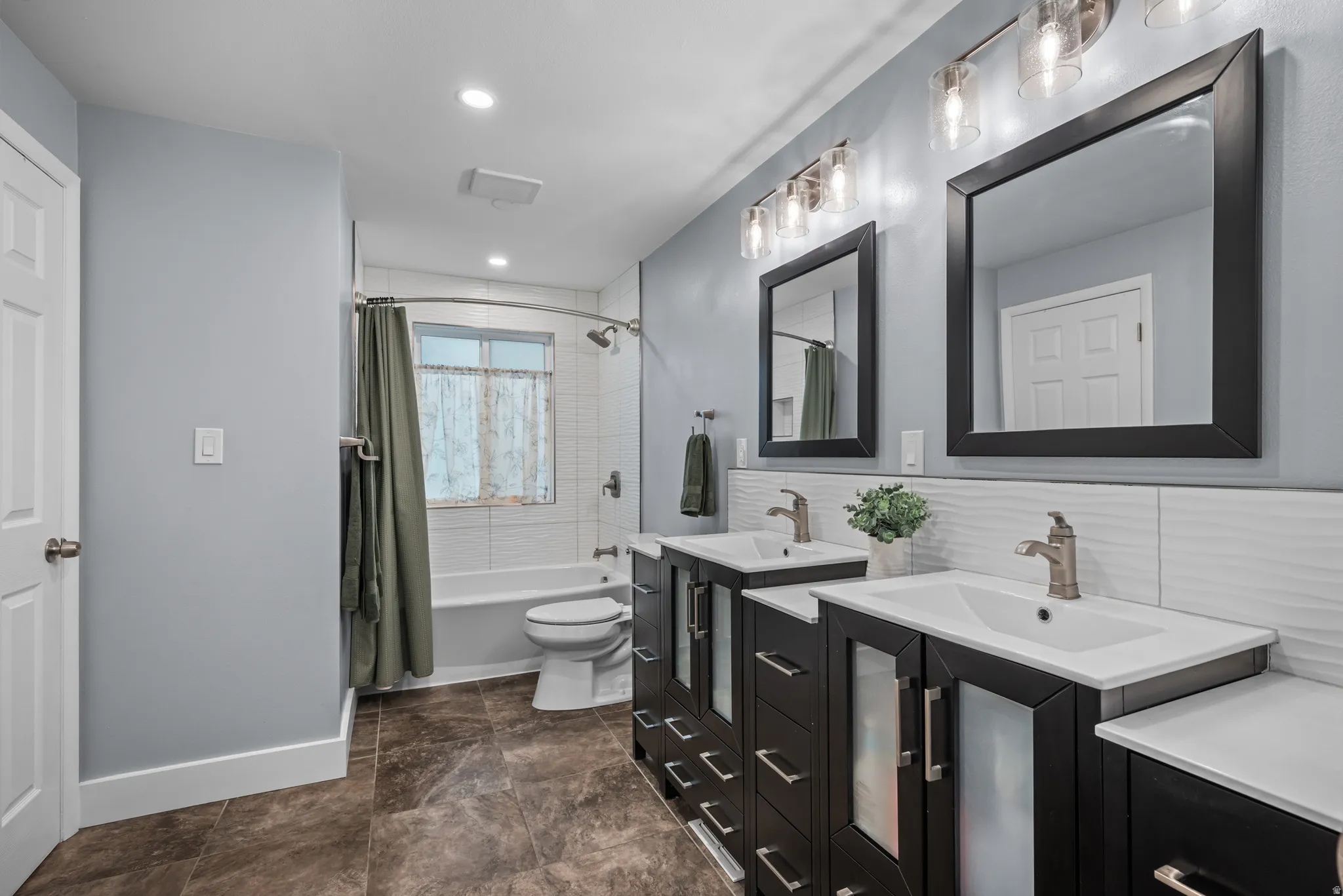 Bathroom featuring a double vanity with dark wood-finish cabinetry, white countertops, and contemporary rectangular mirrors