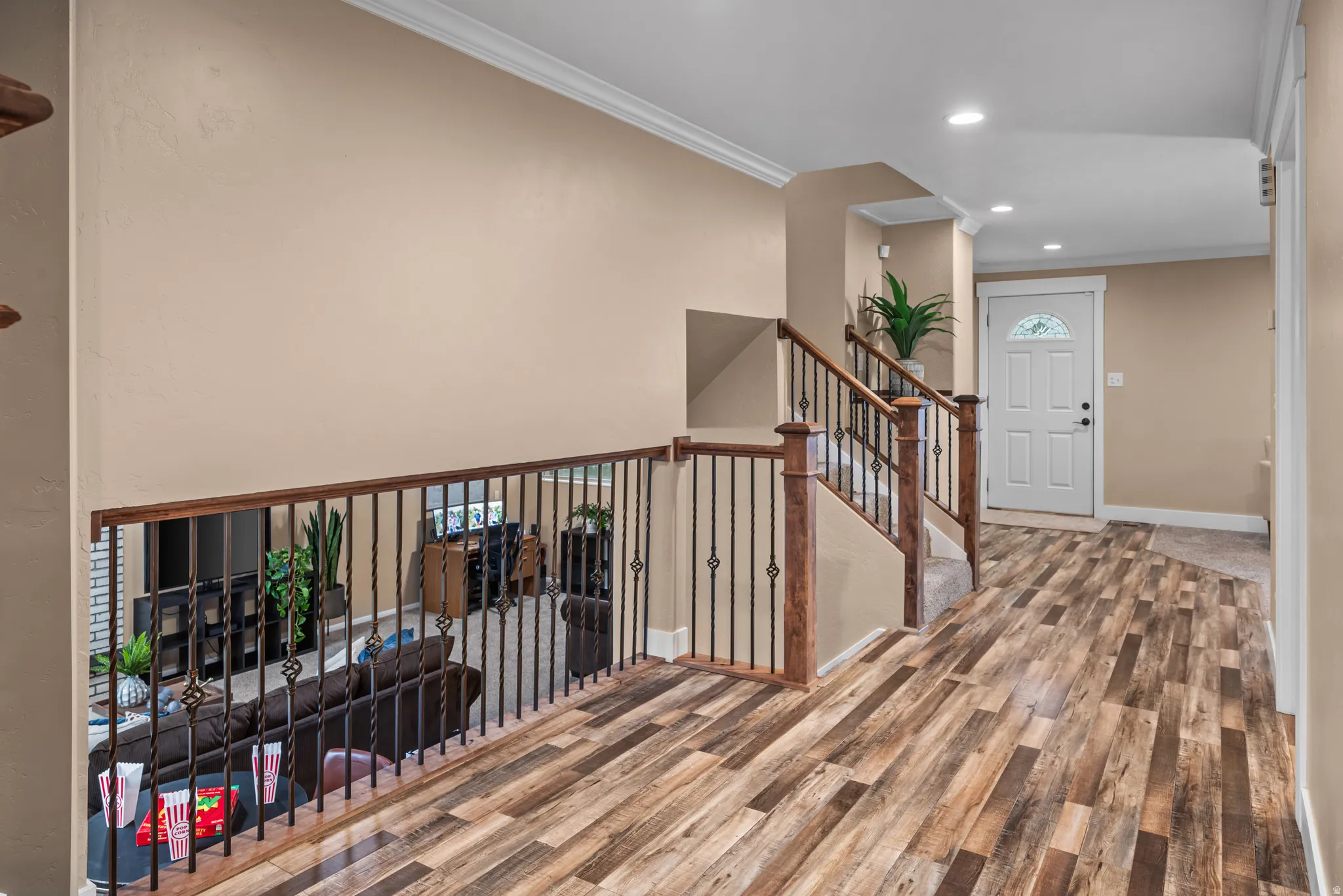Open entryway with wood-finish flooring, a white paneled door with a decorative glass insert, and recessed lighting