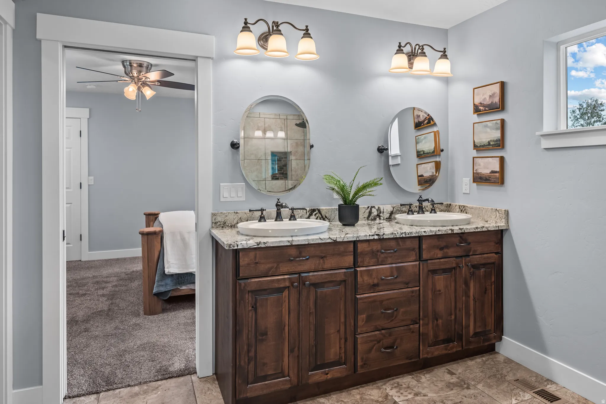 Double vanity with granite countertop, undermount sinks, and dark wood cabinetry