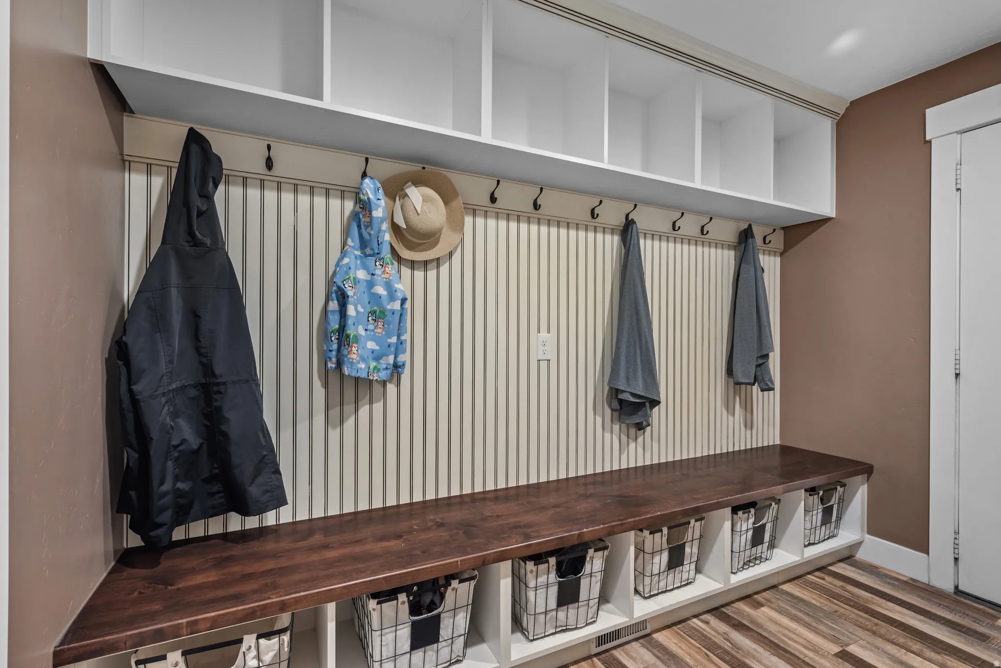Built-in mudroom bench with a rich wood-finish top and integrated storage cubbies