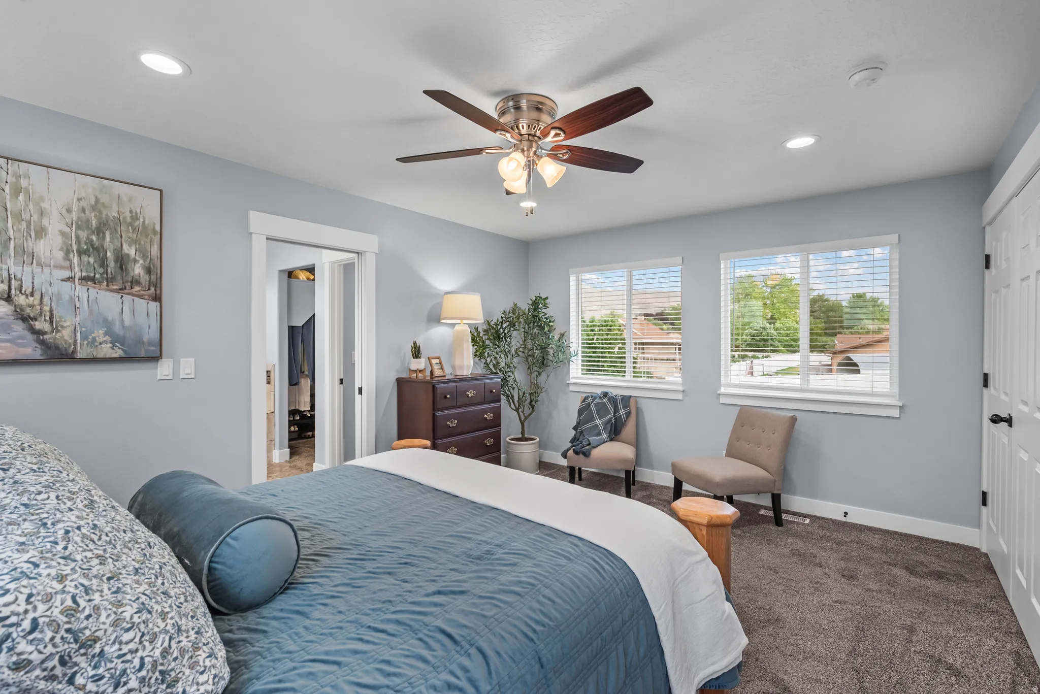 Spacious room featuring dual windows with blinds, recessed lighting, a ceiling fan with light fixture, carpeted flooring, and a white paneled door
