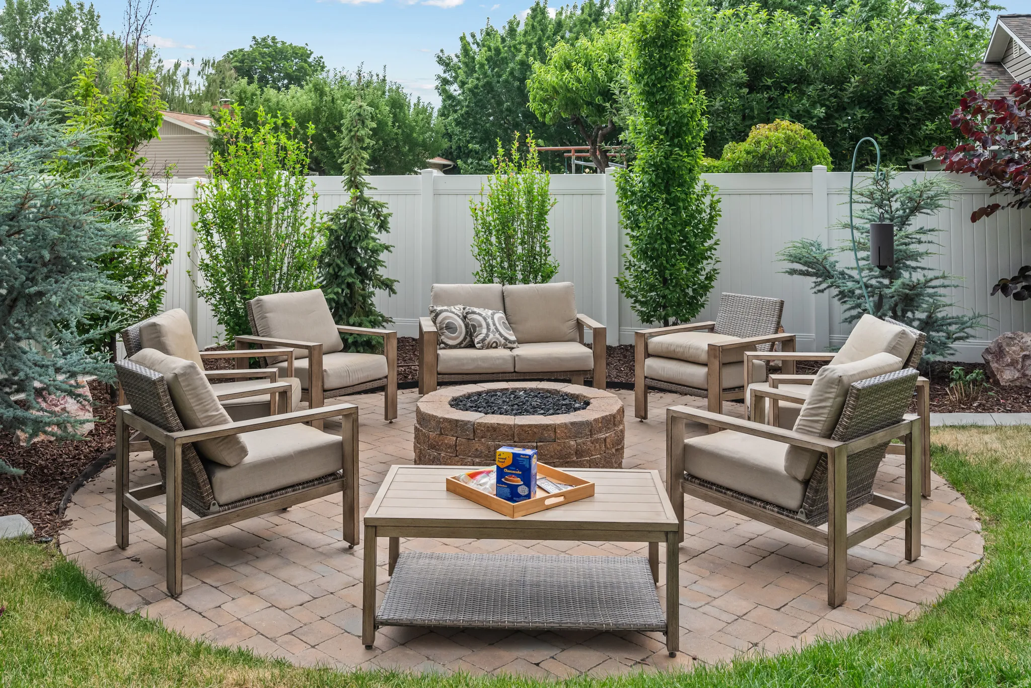 Circular paver patio featuring a built-in fire pit with lava rock