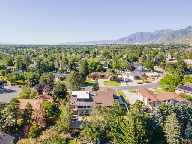 Spacious suburban setting with mountain backdrop and mature trees