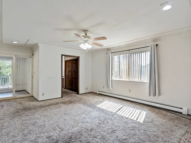 Spacious room featuring broadloom carpeting, crown molding, a ceiling fan with integrated lighting, and recessed lighting