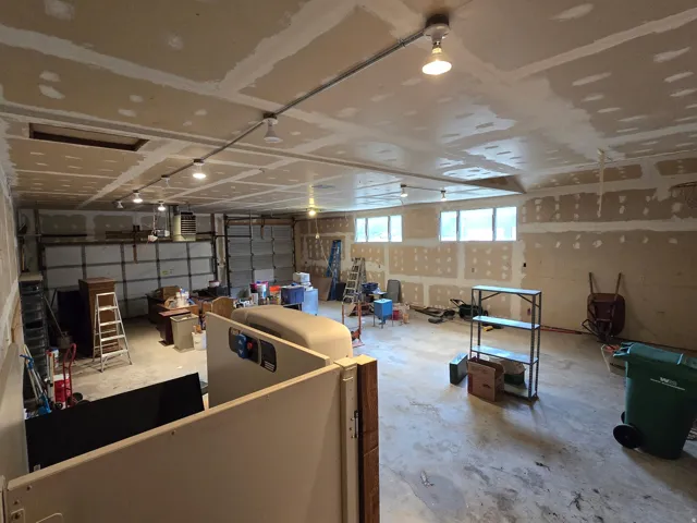 Unfinished interior space featuring a concrete floor, exposed drywall, and multiple windows