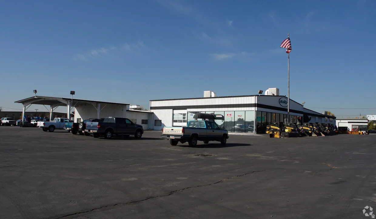 Large commercial building featuring a black and white facade with extensive glass frontage and a prominent flagpole