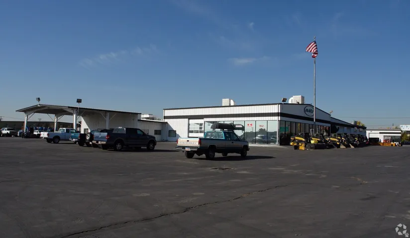 Large commercial building featuring a black and white facade with extensive glass frontage and a prominent flagpole