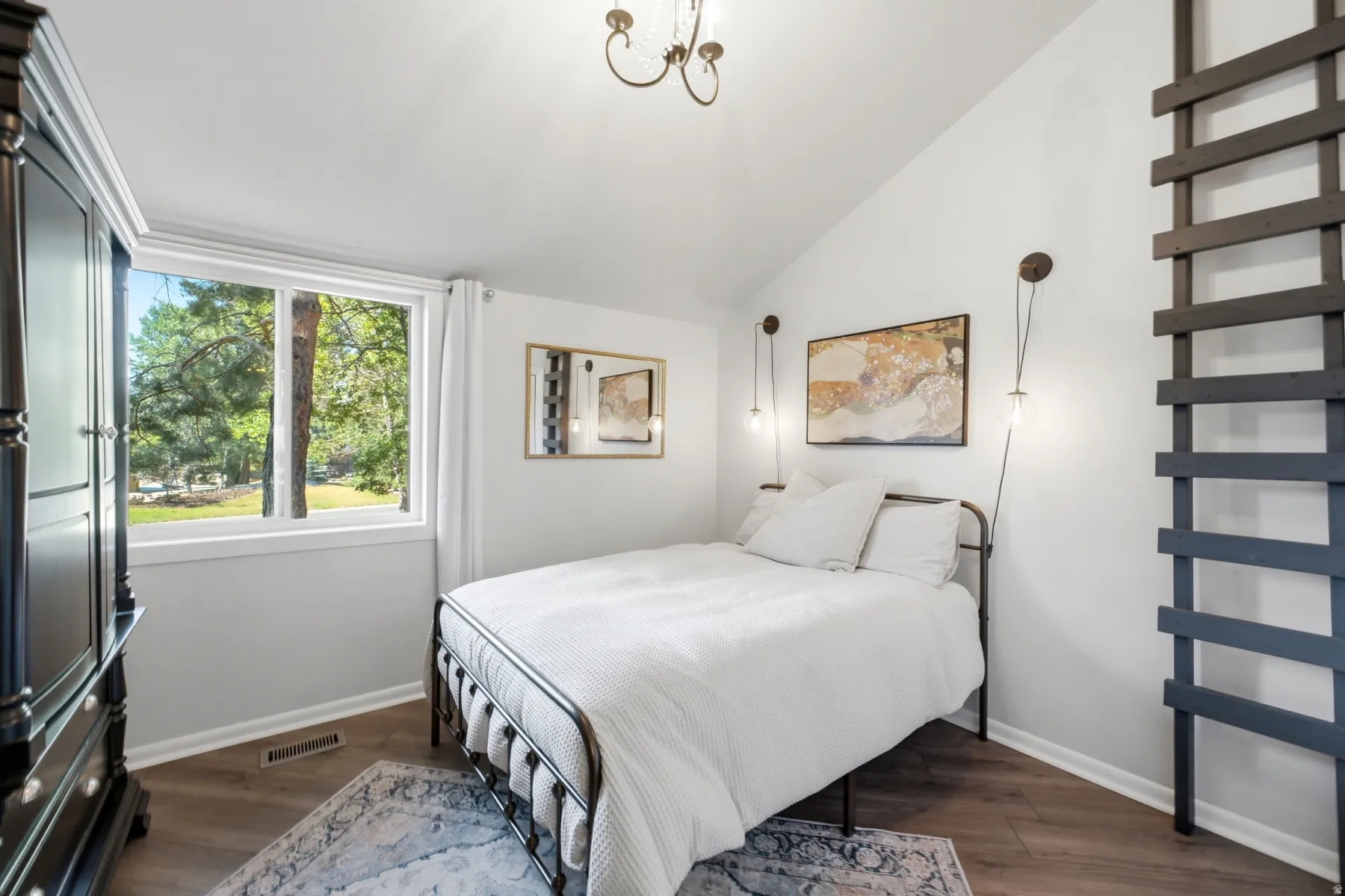 Bright room featuring a vaulted ceiling and a large window