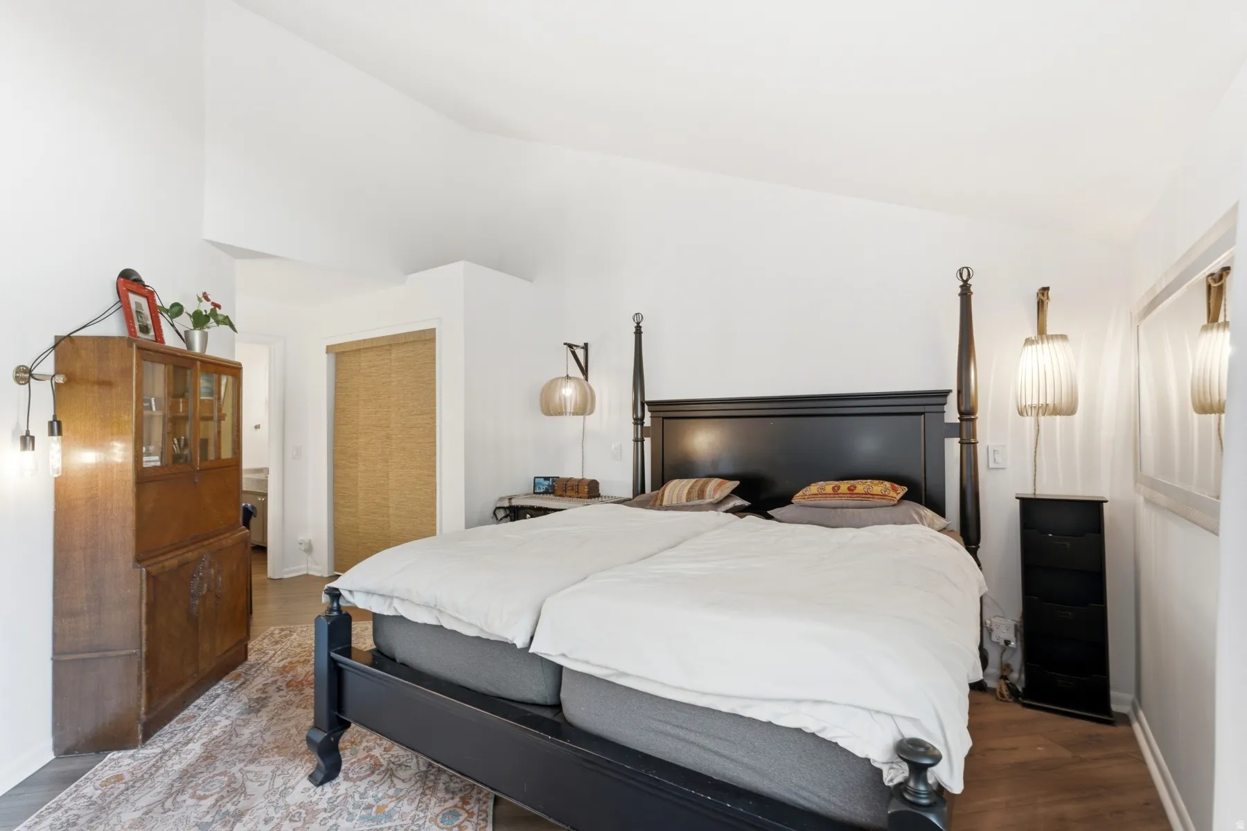 Spacious bedroom featuring vaulted ceilings and wood-finish flooring