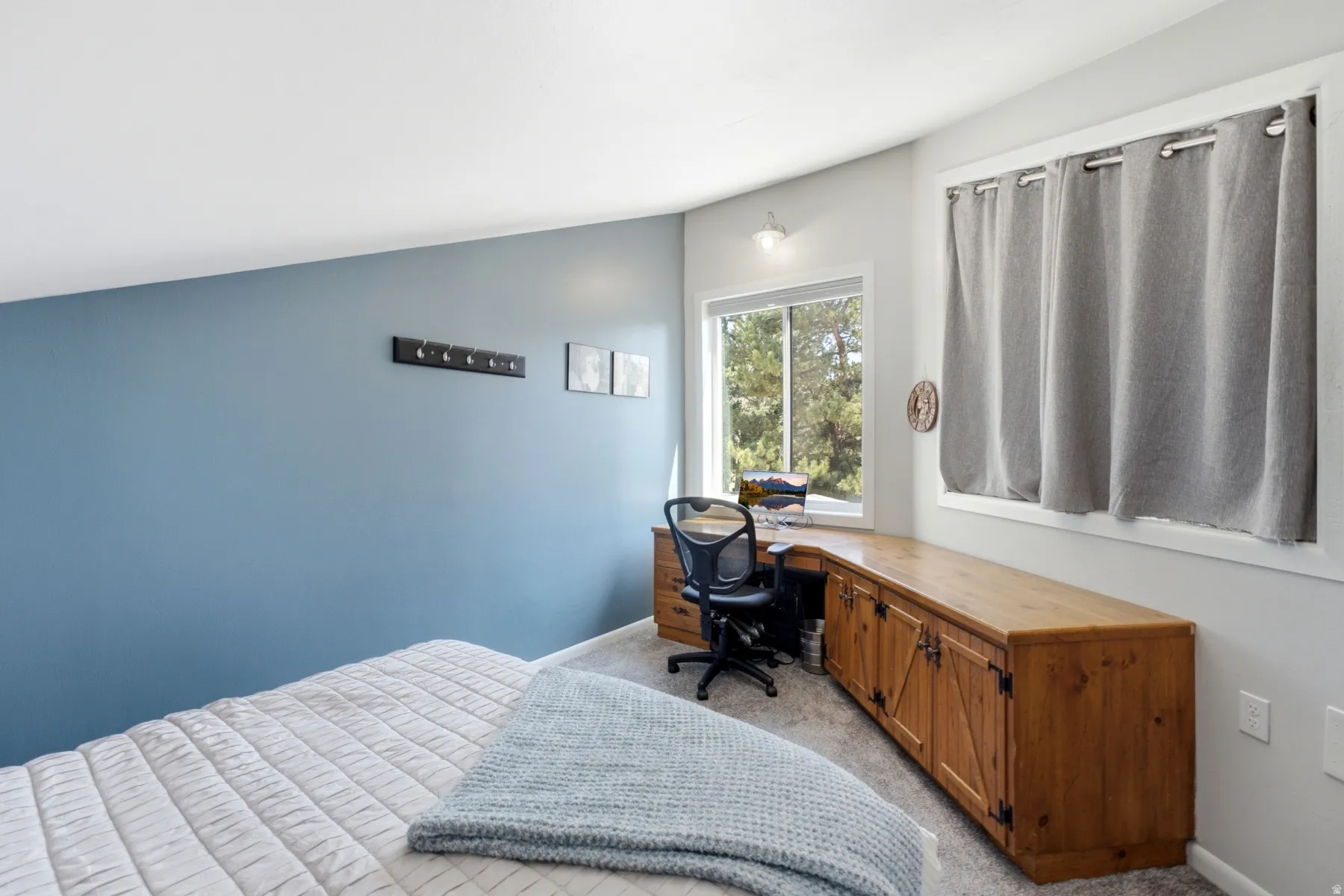 Integrated wood-finish desk and cabinetry featuring barn door style accents