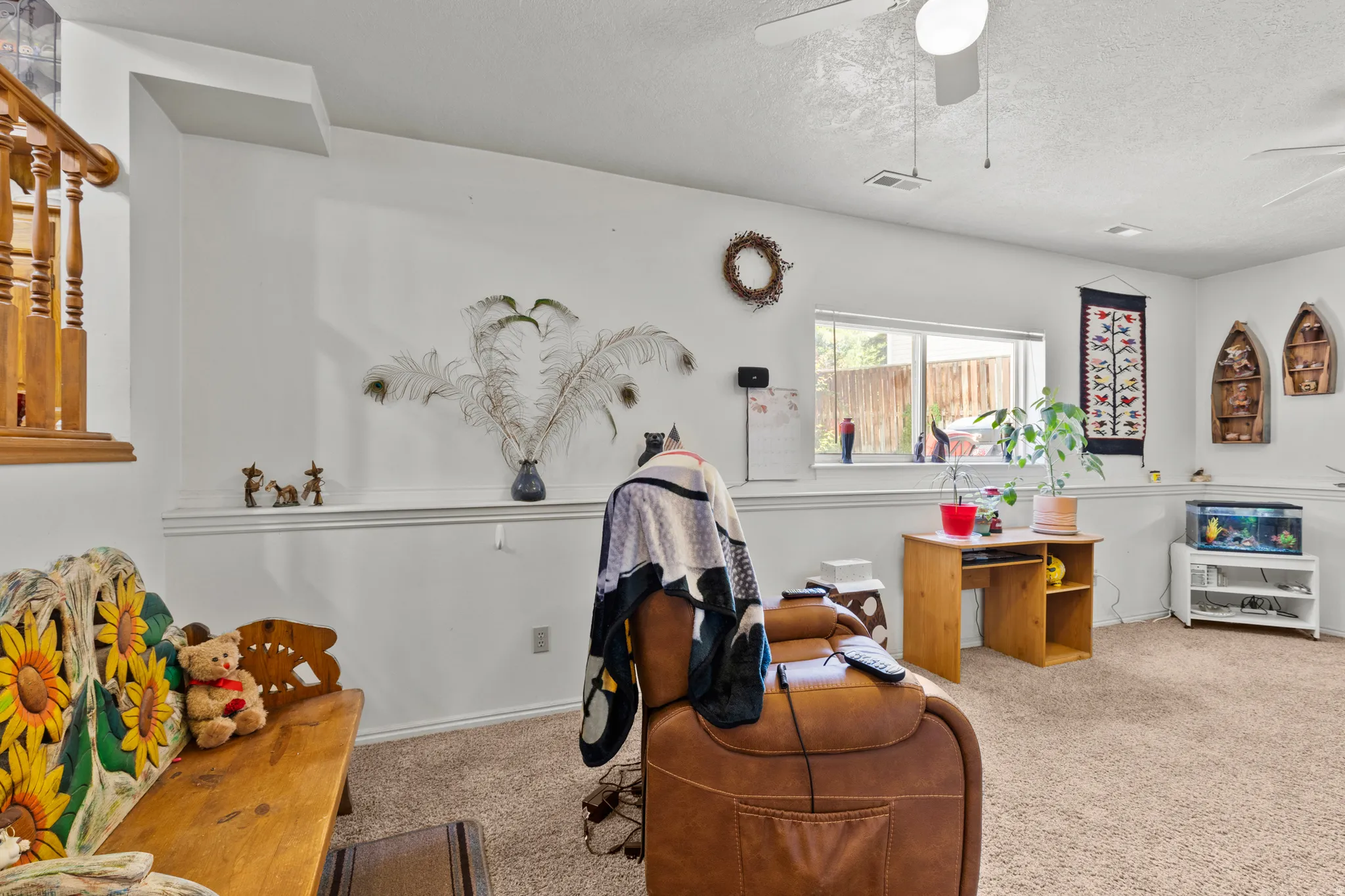 Carpeted living area featuring white walls, a dado rail, and a window with outdoor visibility