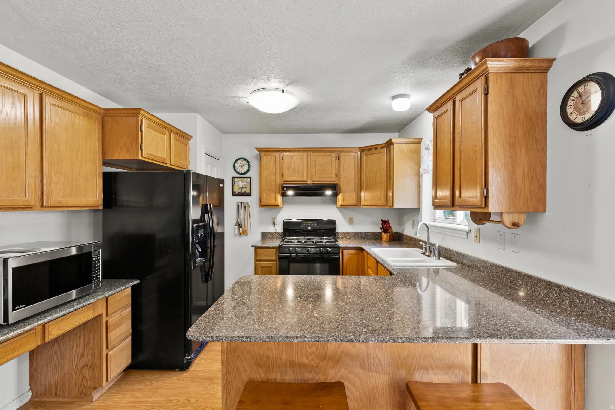 Kitchen featuring light wood cabinetry and stone-finish countertops