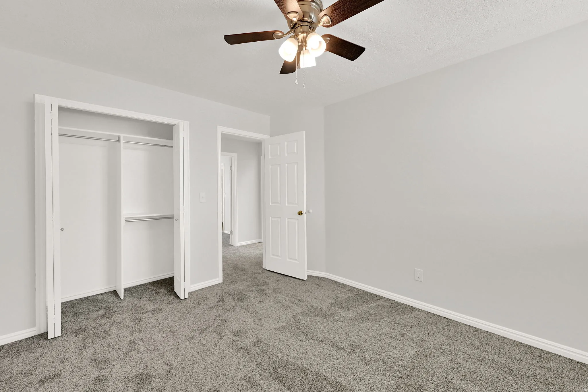 Room with light gray walls, gray carpet, and white trim