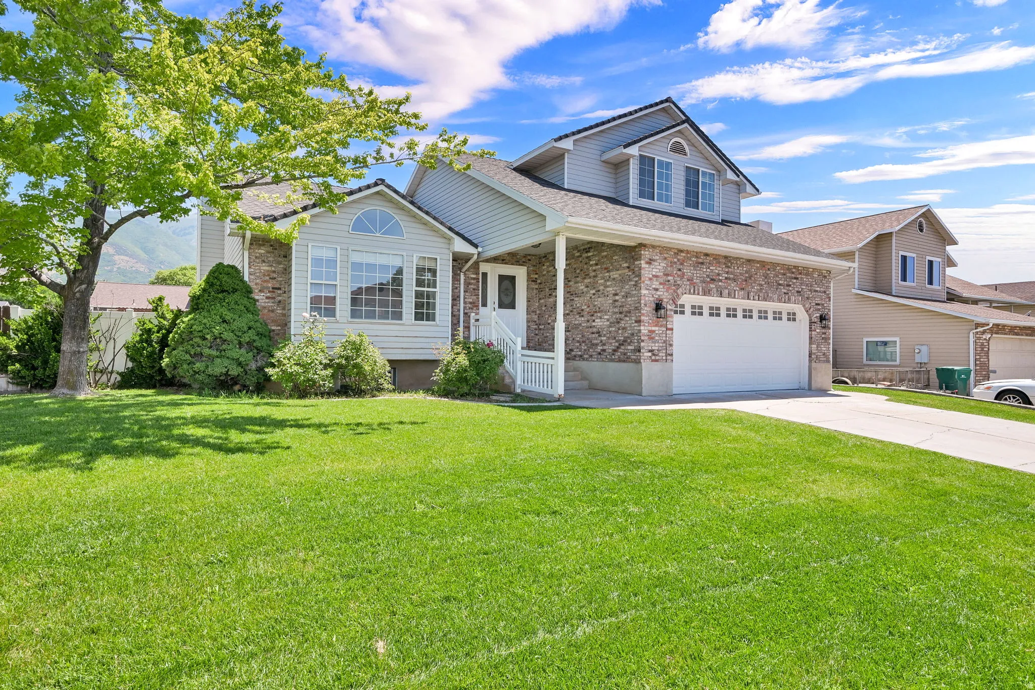 Brick and siding exterior featuring a two-car garage with white door