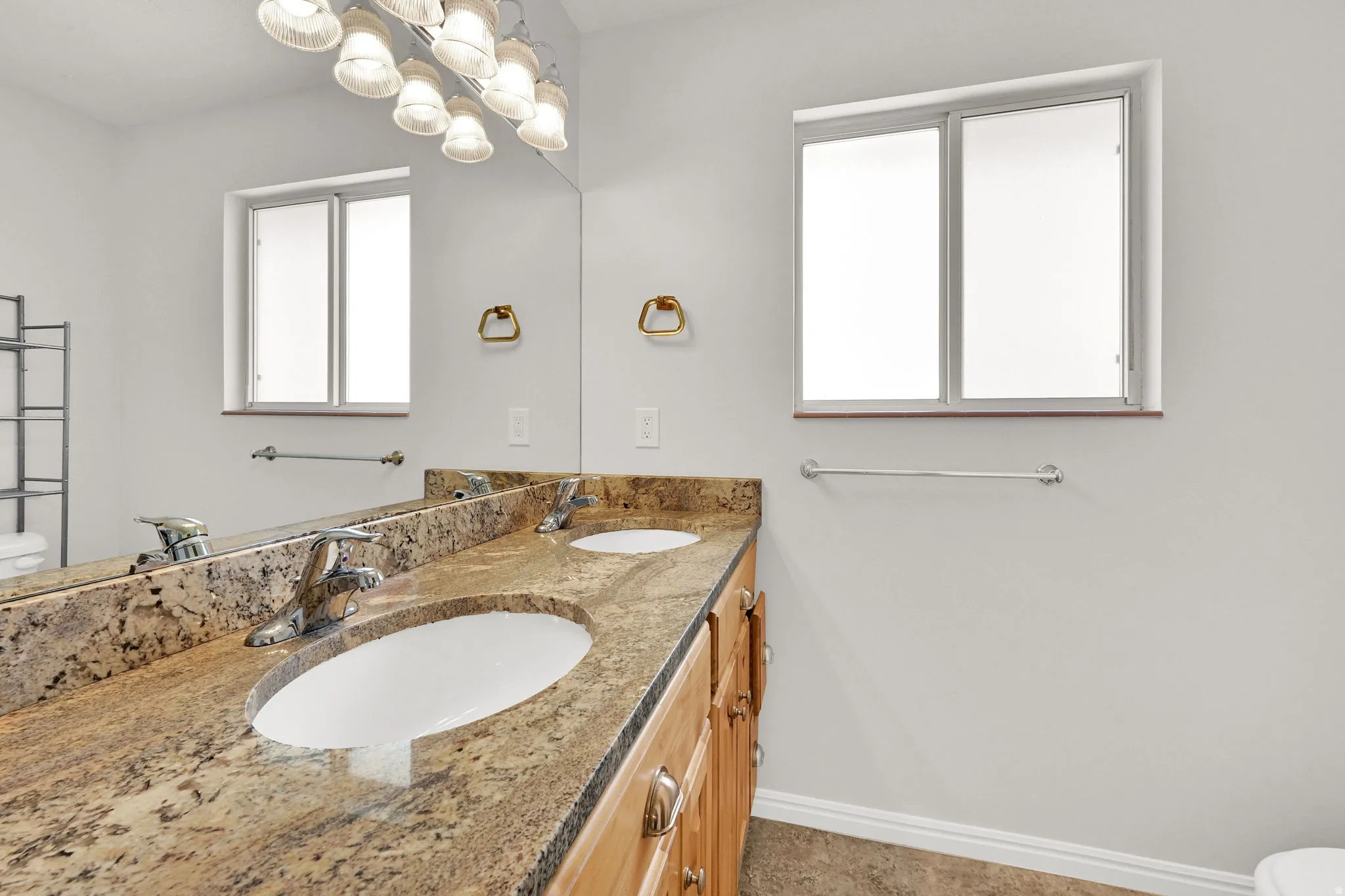 Double vanity with a granite countertop, dual undermount sinks, and chrome fixtures