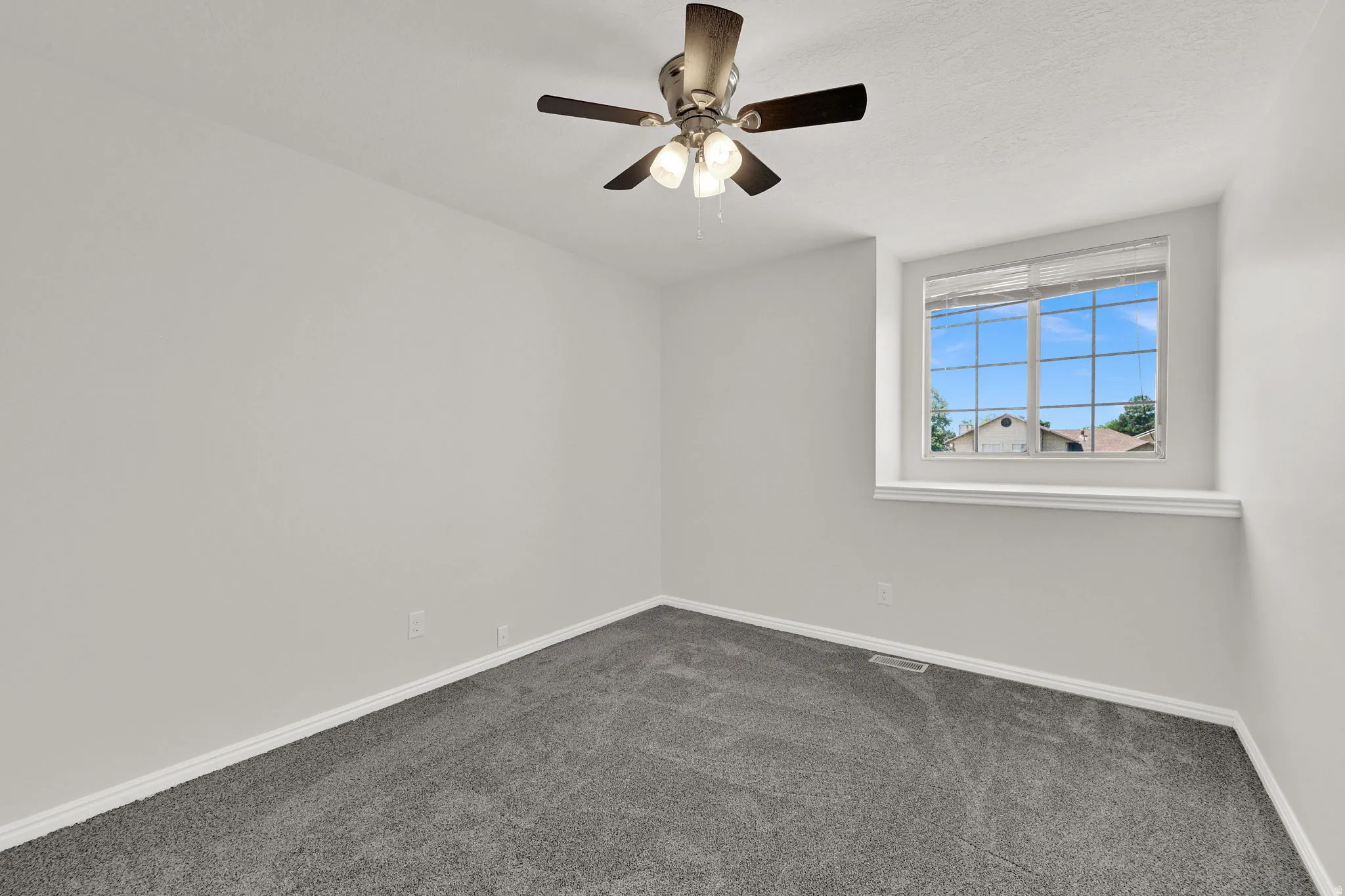 Room featuring a window with integrated blinds, a ceiling fan with light fixture, and gray carpeting