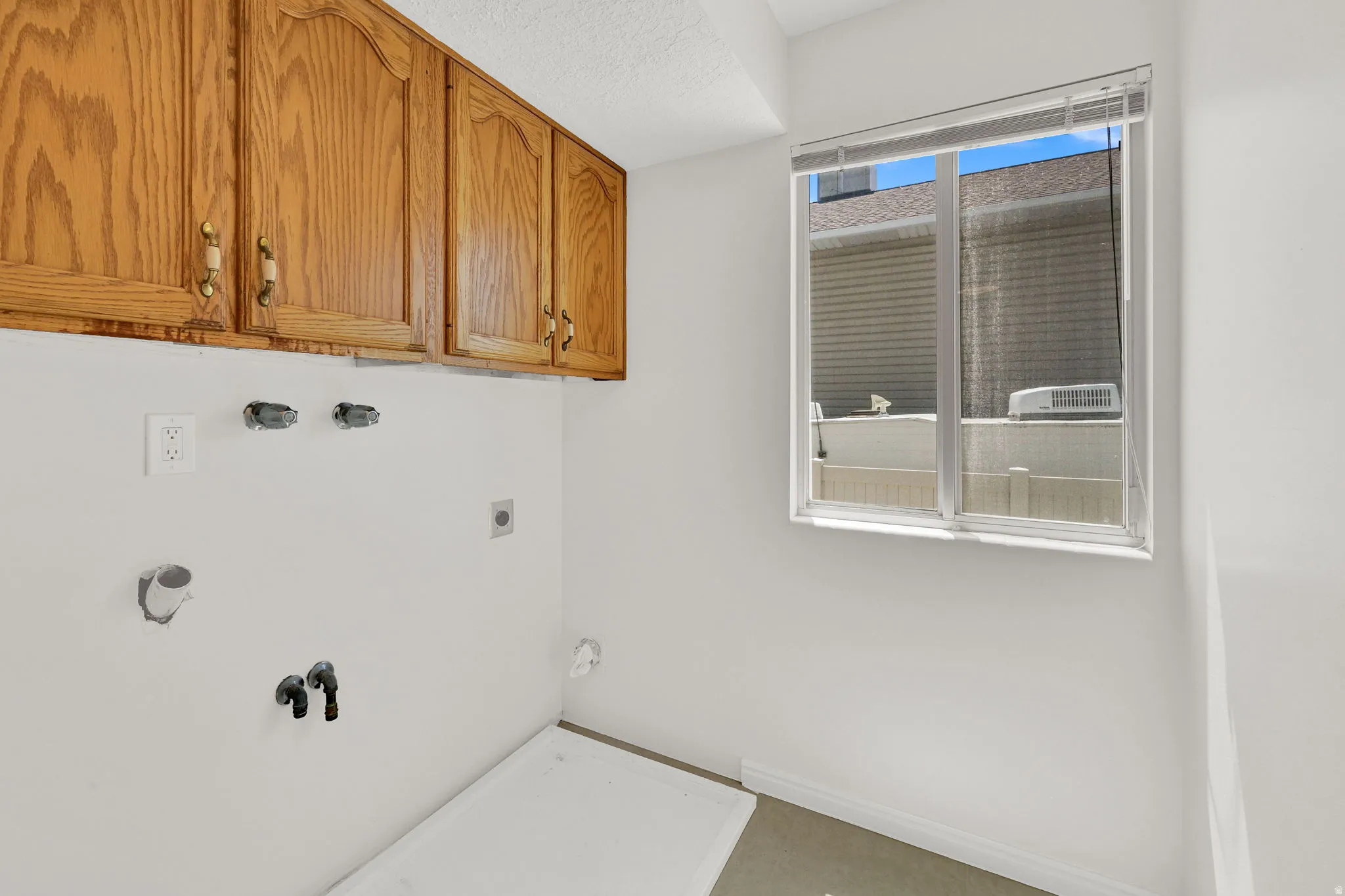Utility space featuring wood-finish cabinetry with decorative hardware
