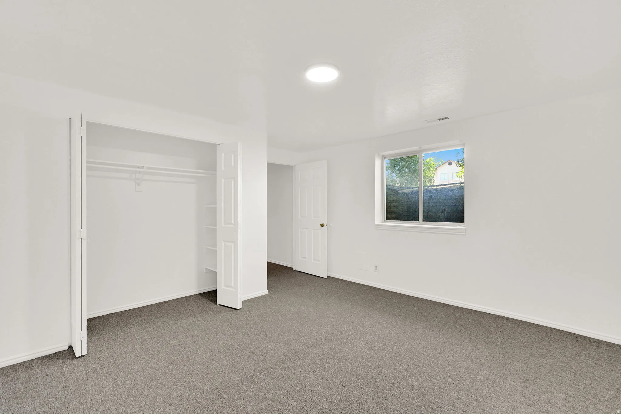 Spacious room featuring neutral carpeting and white wall finishes