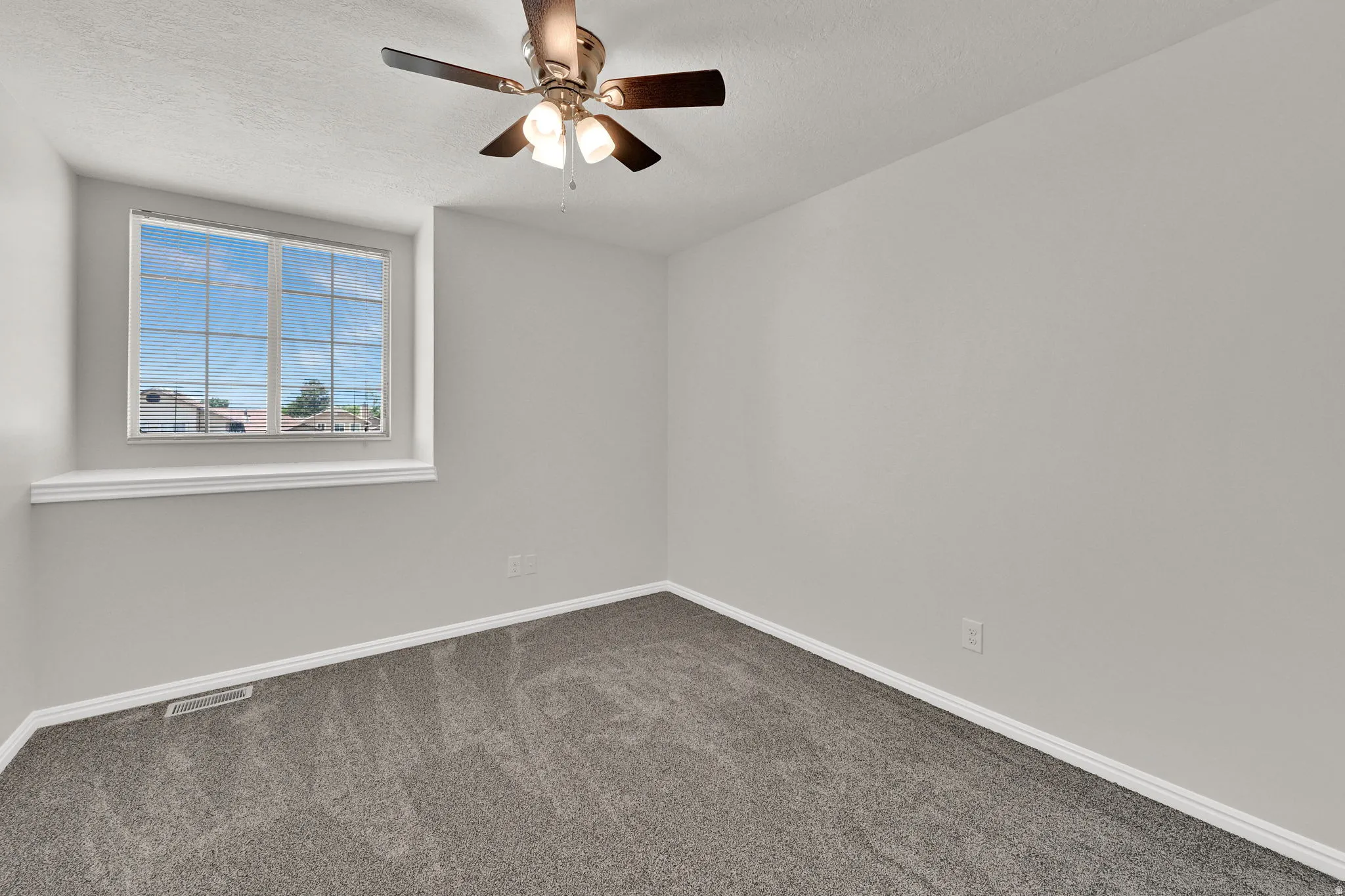 Neutral gray wall paint, dark gray carpeting, and white trim