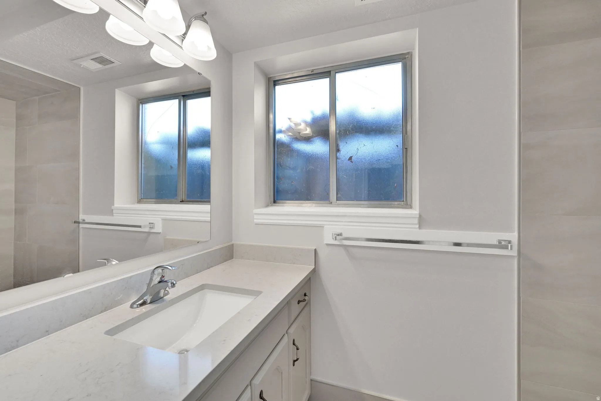 Bathroom vanity featuring an integrated sink, polished chrome faucet, and spacious countertop
