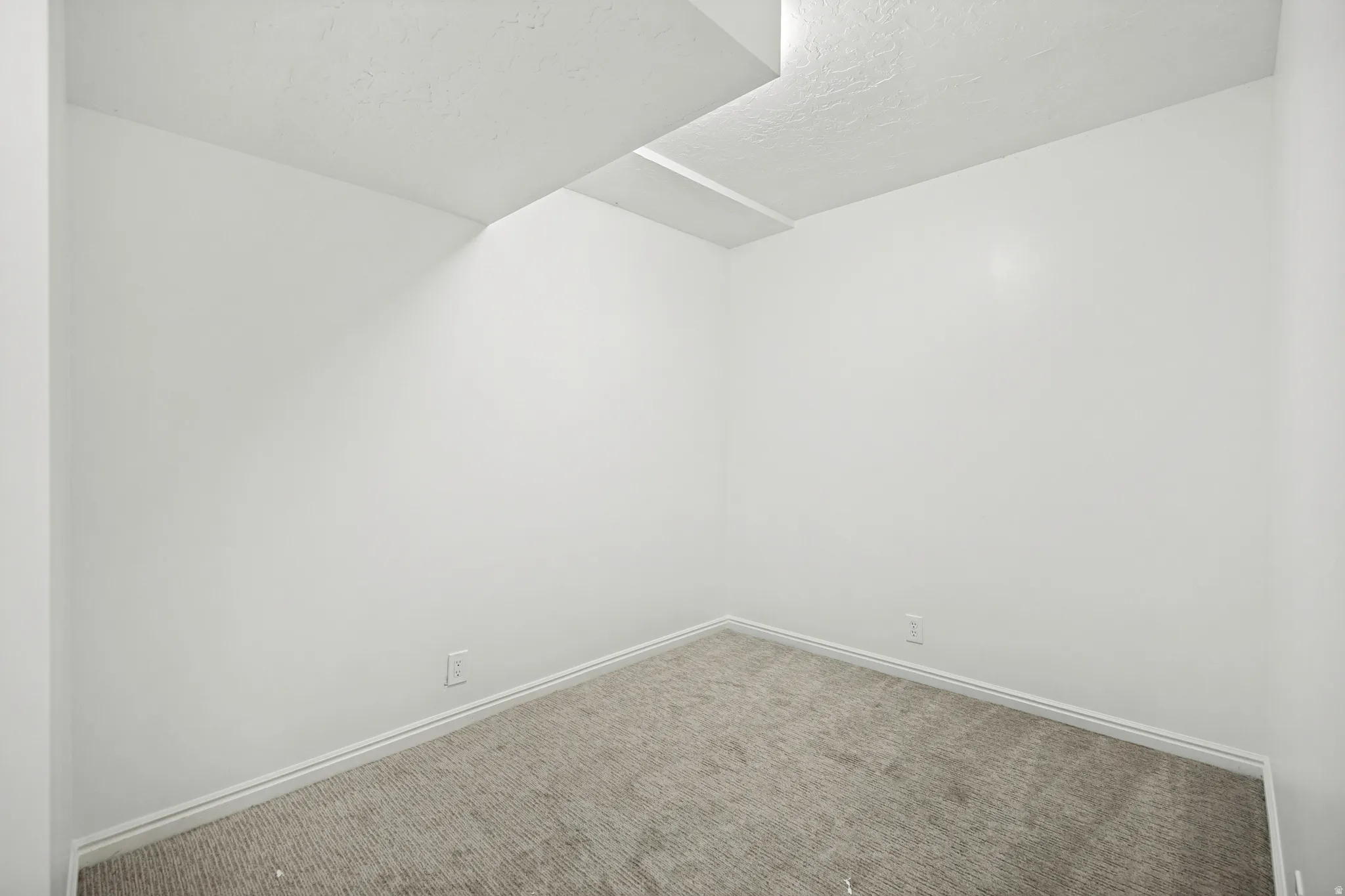 Room featuring light gray carpeting, white baseboards, and white walls