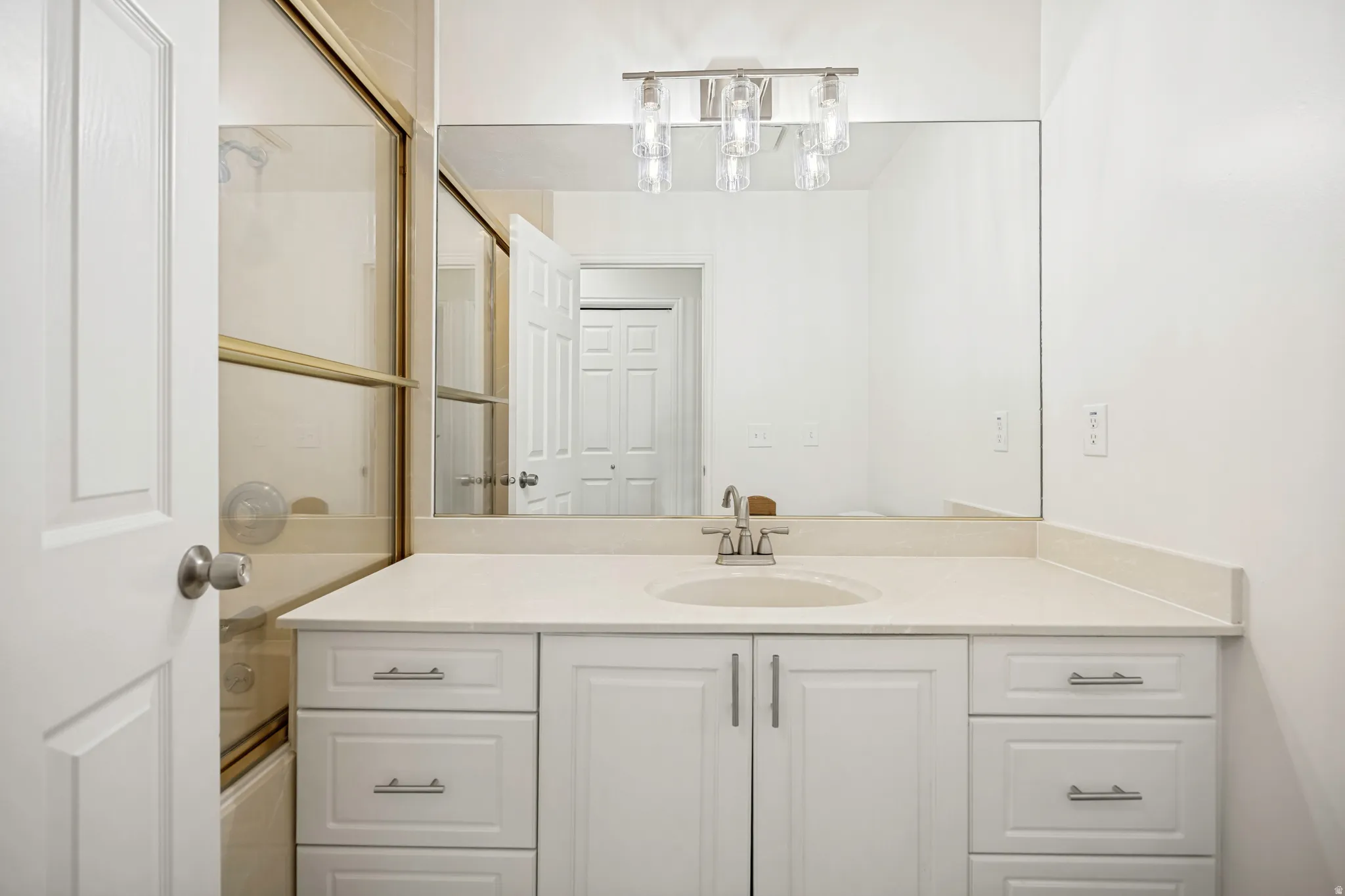 Bathroom vanity featuring an integrated sink, polished chrome faucet, and ample storage cabinetry