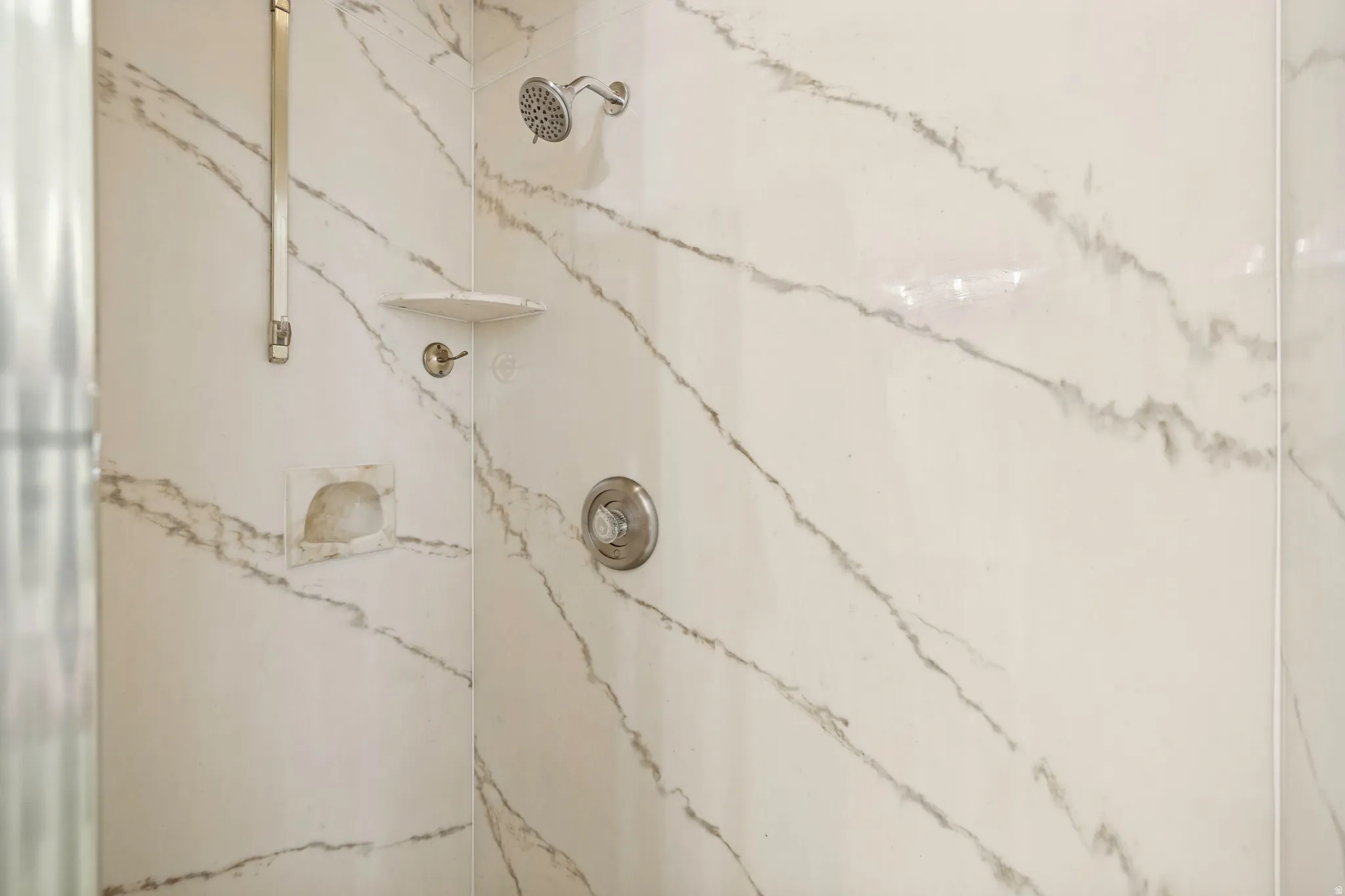 Shower enclosure featuring white and grey veined wall panels