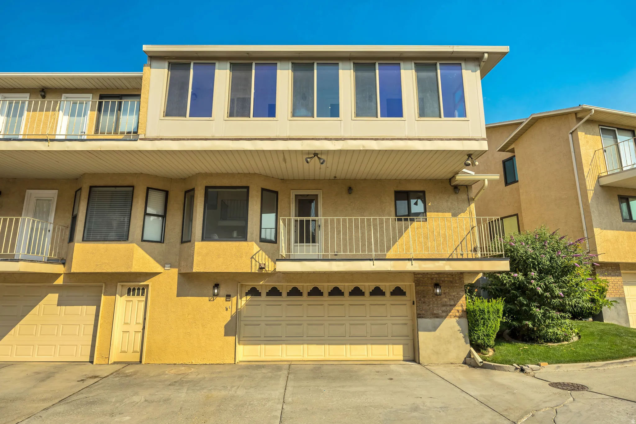 Multi-level exterior with stucco finish and a multi-pane upper-level window