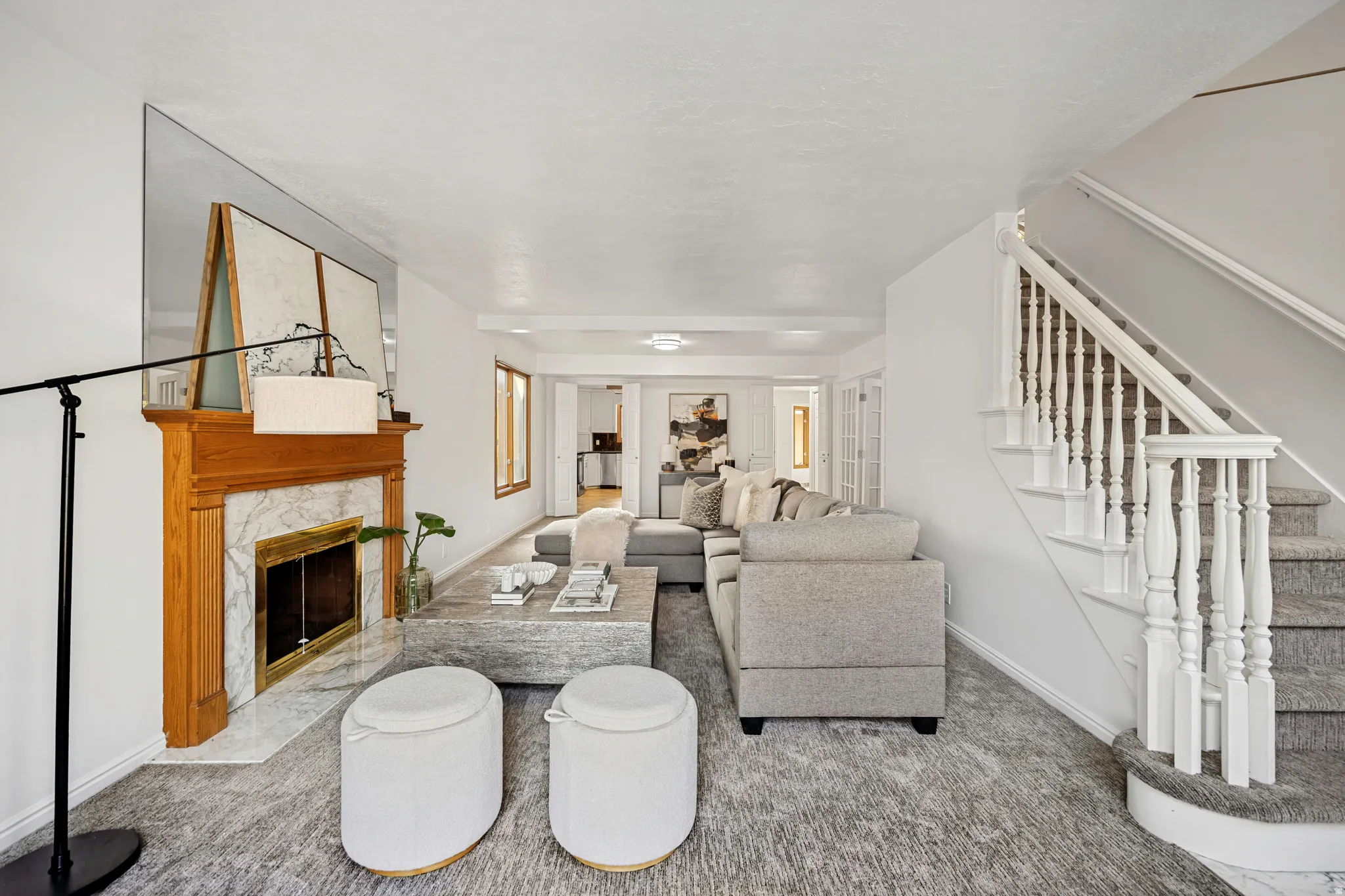 Living area featuring a classic wood mantel fireplace with a marble surround and a gold-toned firebox