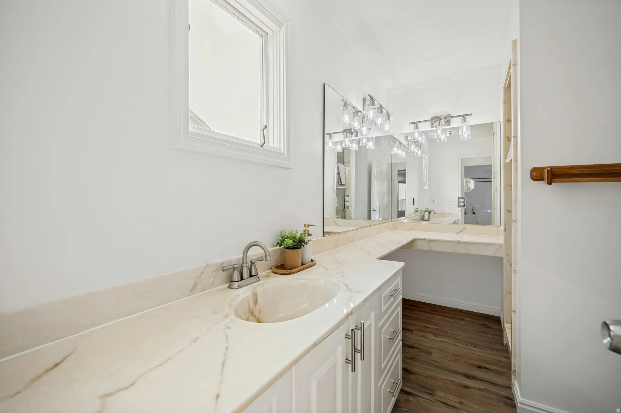 Bathroom vanity featuring an integrated sink, polished chrome faucet, and expansive countertop