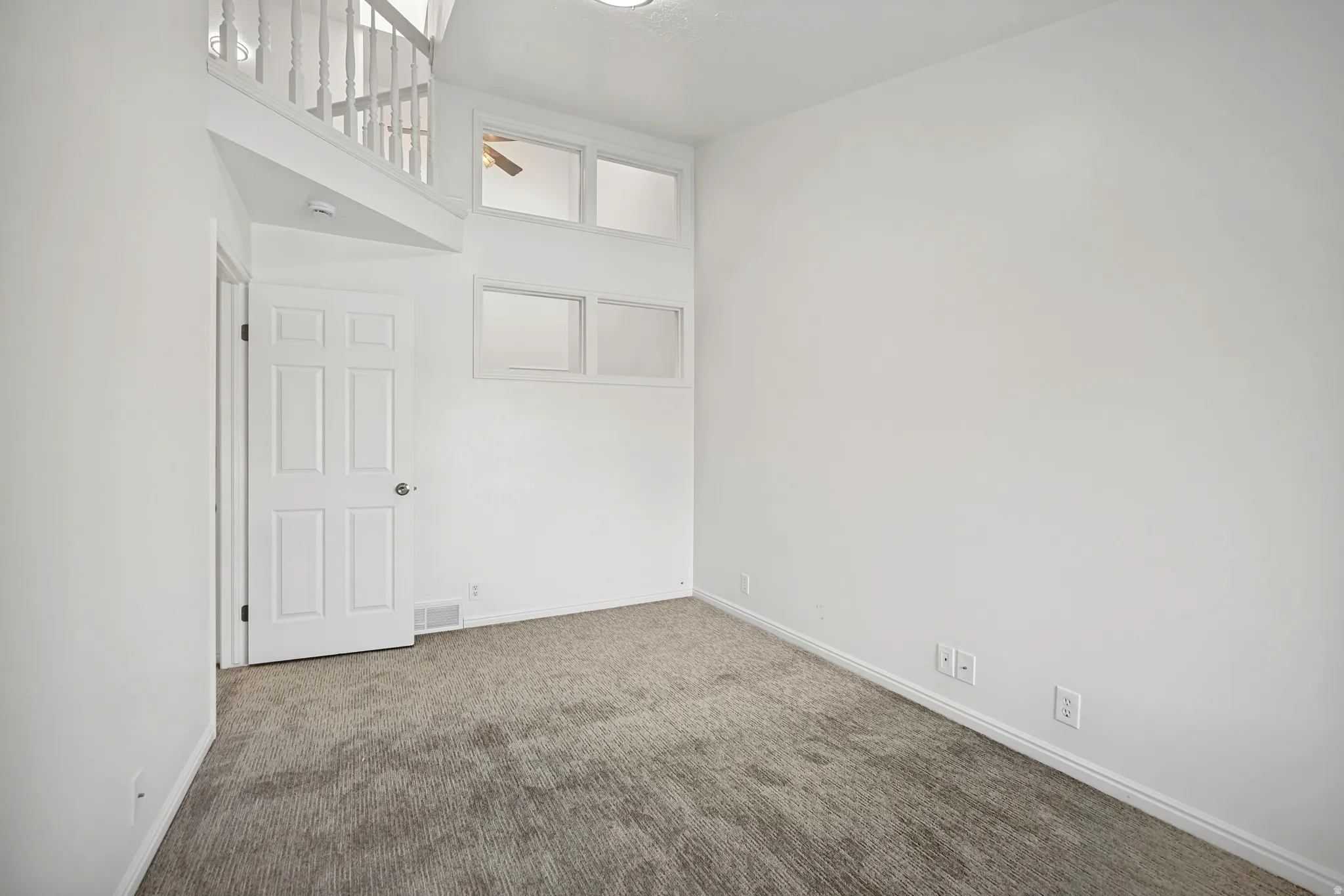 Room featuring neutral-toned carpeting, white walls, and a multi-paneled interior door