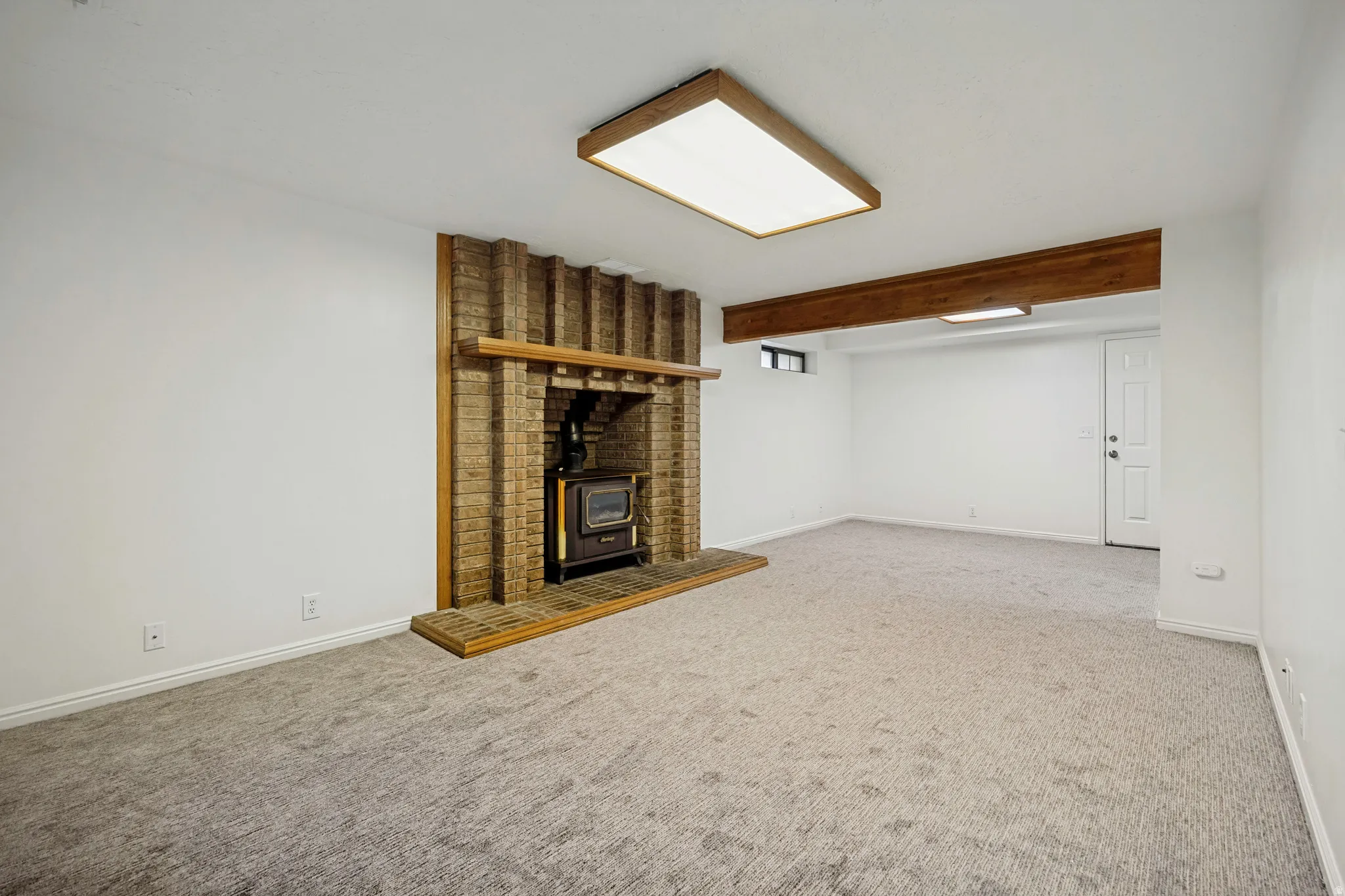 Interior space featuring a brick fireplace with a wood-burning stove insert