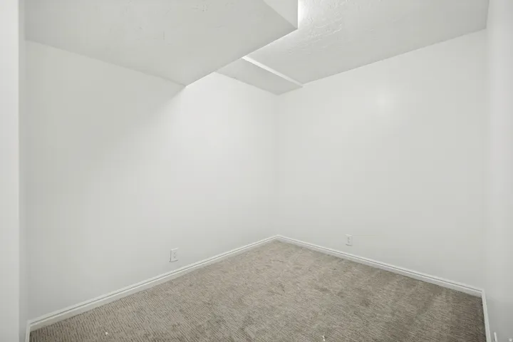 Room featuring light gray carpeting, white baseboards, and white walls