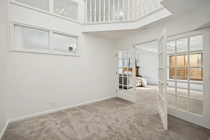 Two-story entry foyer featuring a balcony overlook, white spindle railing, and multiple transom windows