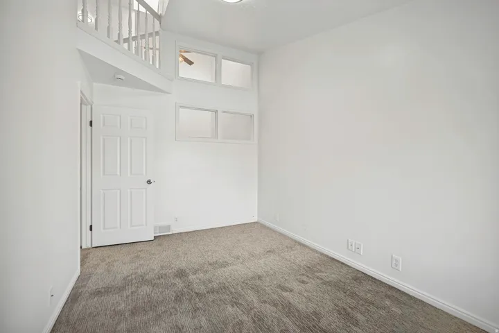 Room featuring neutral-toned carpeting, white walls, and a multi-paneled interior door