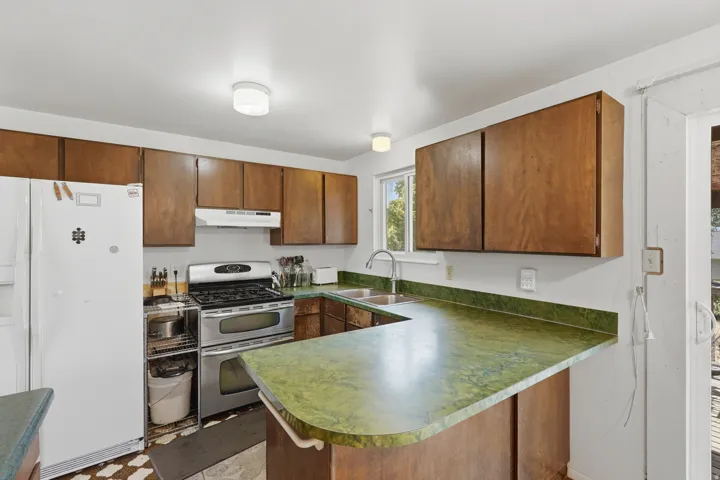 Kitchen featuring wood cabinetry, green countertops, and a white refrigerator
